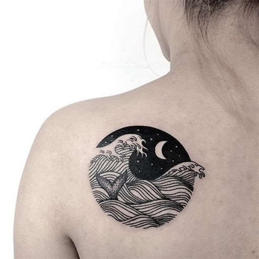Uma vinheta de uma noite mostra uma paisagem marinha cresting onda com um rabo de baleia fora da água, enquanto uma lua crescente senta-se no fundo.