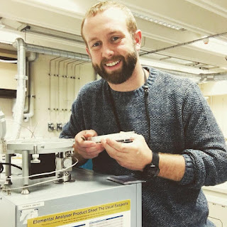 Nick Patton placing packed sediments within a mass spectrometer for isotope analysis.