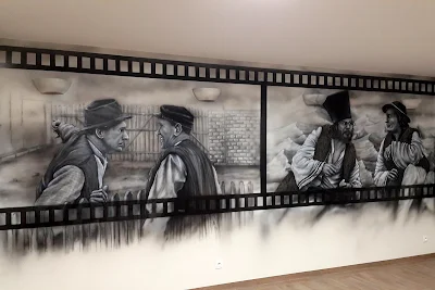 Artystyczne malowanie ściany w motyw z filmu "Sami Swoi", czarno-biały mural w sali telewizyjnej