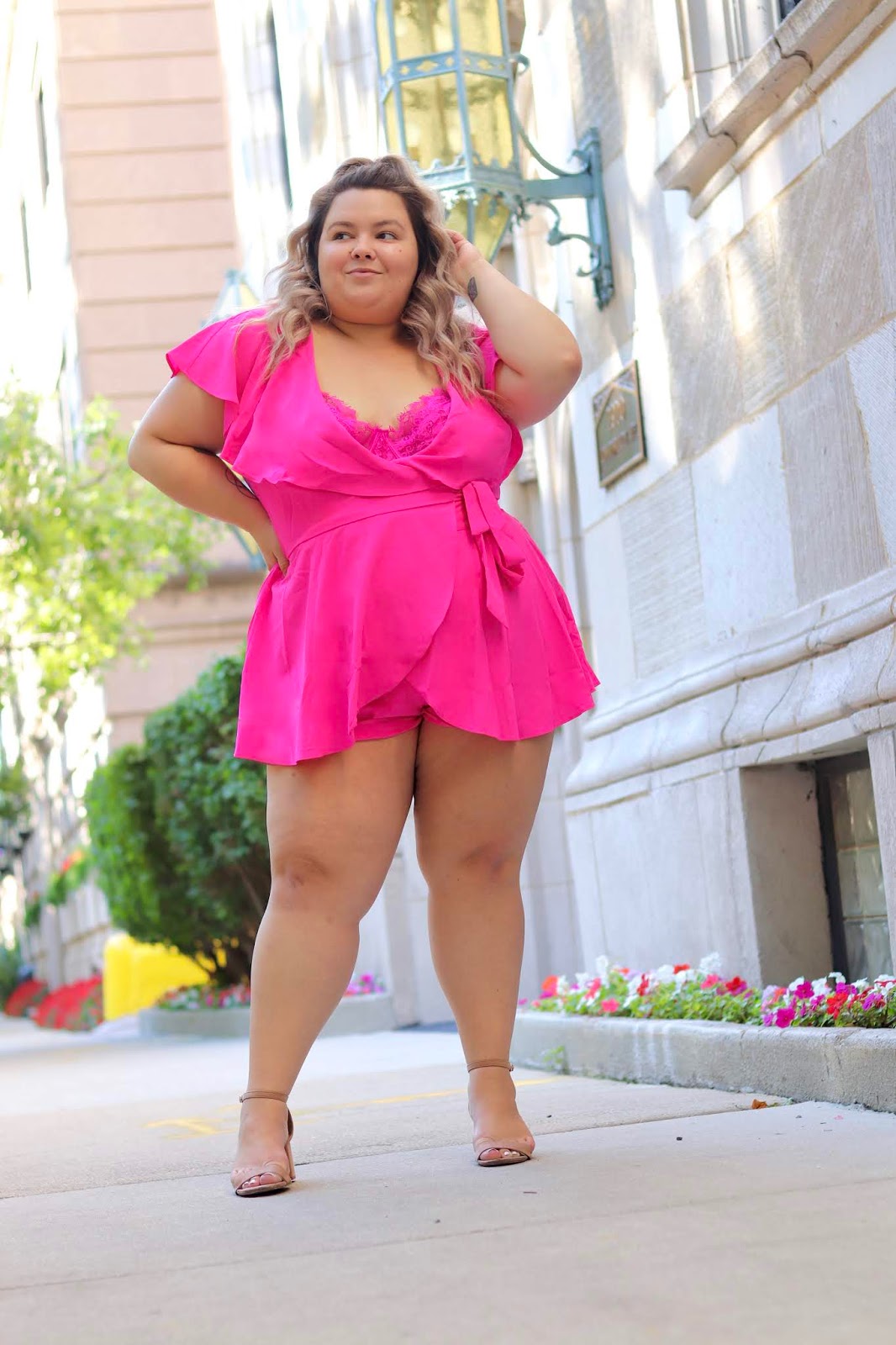 Chicago Plus Size Petite Fashion Blogger Natalie in the City wears a pink plus size romper.