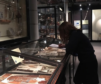 Langtree student sketching in the Pitt Rivers Museum School pupil leaning on glass case in Museum and sketching