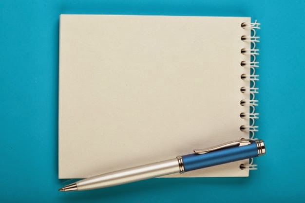 Um bloco de notas e caneta sob fundo azul