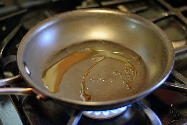 A small non-stick frying pan with a little extra virgin olive oil in it, over the flame on the stove. 