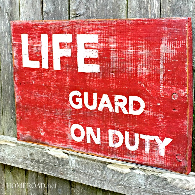 Lifeguard on duty sign heavily distressed in red and white