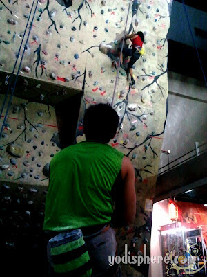 Indoor Wall Climbing - Two people working together to reach the top 