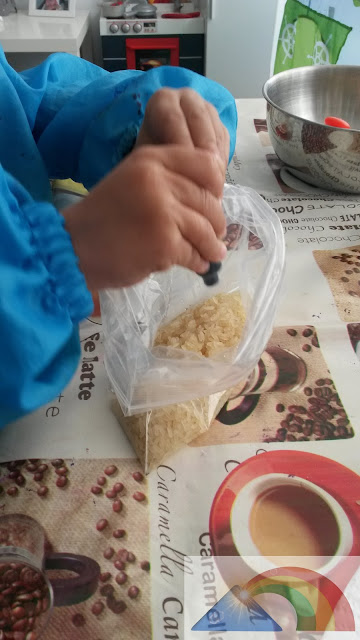 Añadiendo colorante alimentario a las bolsas con arroz y vinagre blanco