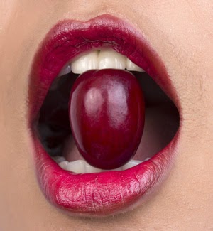 Eating a grape Woman holding a grape between teeth