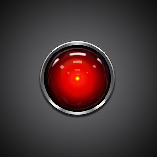 2001: A Space Odyssey - Imagen que muestra el "ojo" del computador Hall 9000, una especie de objetivo de cámara de color rojo en cuyo fondo hay un punto central amarillo, algo parecido a una pequeña pupila