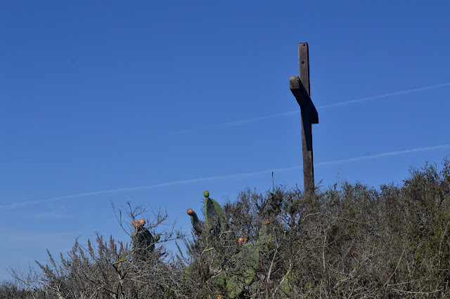 below the cross