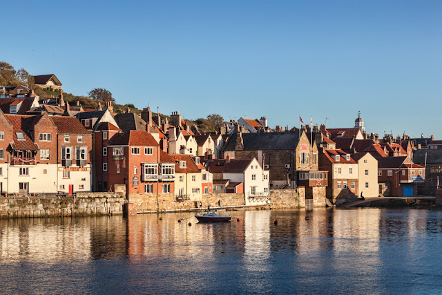 Reflection of houses in warm evening light in Whitby harbour North Yorkshire by Martyn Ferry Photography