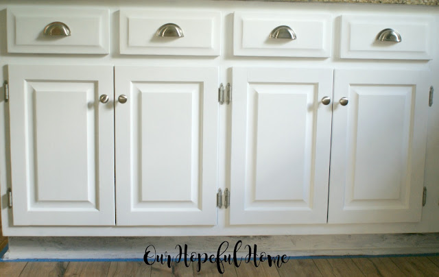 white farmhouse kitchen cabinets with brushed nickel knobs and cup pulls