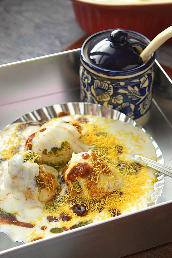 Close up of a silver plate served with soft Dahi Bhalle with sweet date tamarind chutney,Nylon Sev and greenChutney