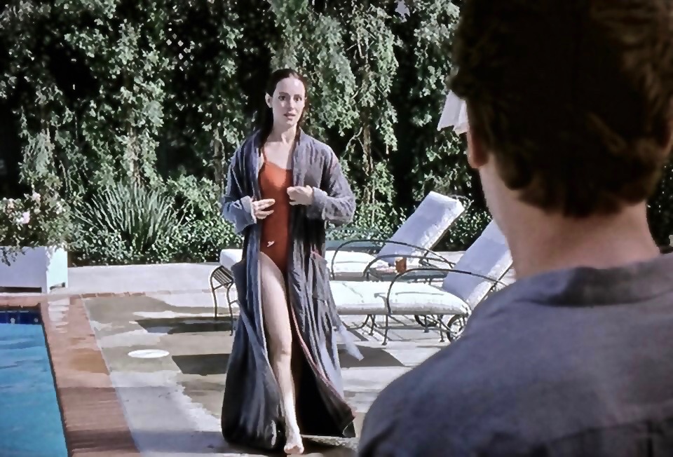 Ray Liotta facing Madeline Stowe poolside in Unlawful Entry.