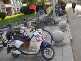 electric scooter with an American flag and "go with me" design with a Chinese flag flying on it in Mudanjiang, China