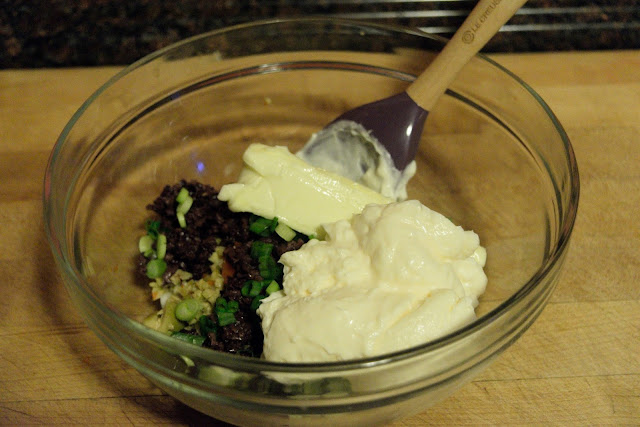 Mayonnaise being added to the butter and chopped ingredients in the bowl.  