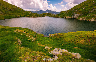  lake in mountains with grass on hillside