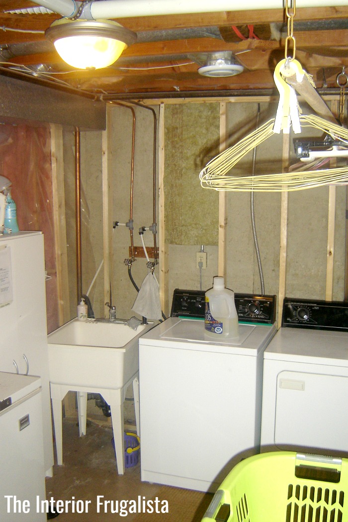 A dark and dreary basement laundry room before $500 laundry room makeover.