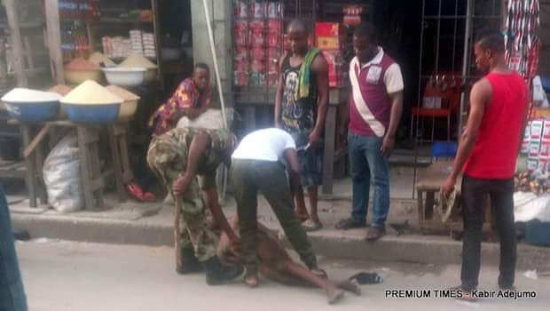 Photos: Two soldiers caught on camera beating a commercial tricycle rider in Lagos after stripping him naked, threatens to cut off his penis