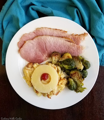 Scalloped pineapple is a perfect slightly sweet side dish to go along with a salty ham dinner. It will feel right at home on your holiday plate! plate loaded with ham, brussels sprouts and pineapple casserole
