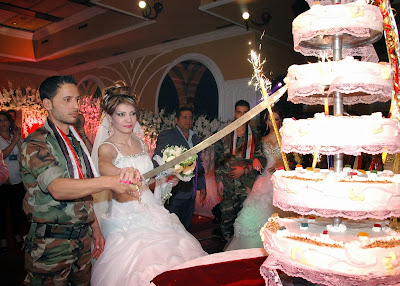 Syrian soldier and his bride cutting a wedding cake