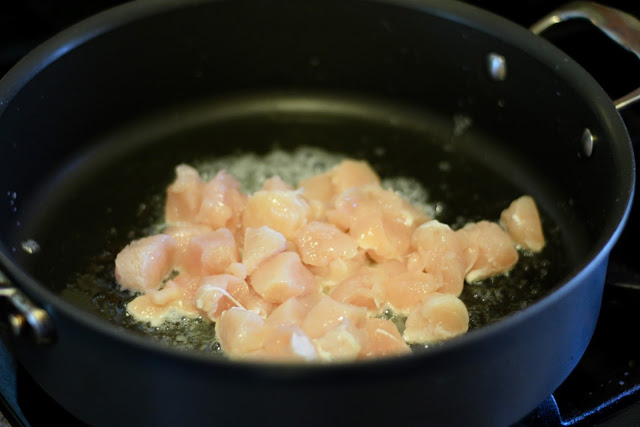 Boneless, skinless chicken breast browning in a pan. 