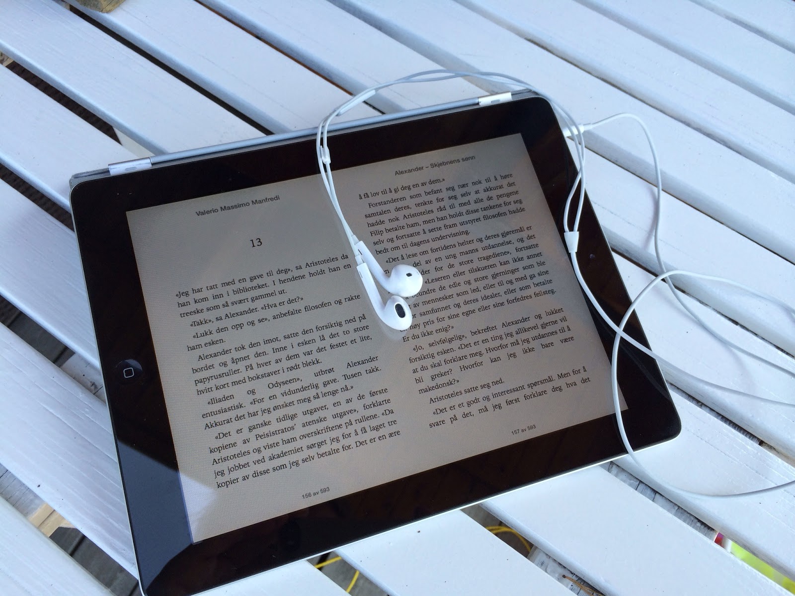 Bilde av en iPad med iBook og øreplugger