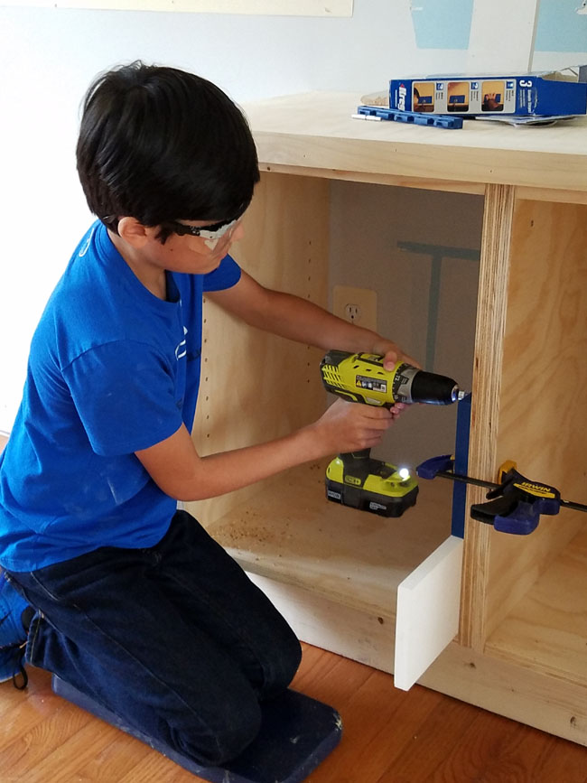 built-ins with shelf holes - boy driving holes with Ryobi drill