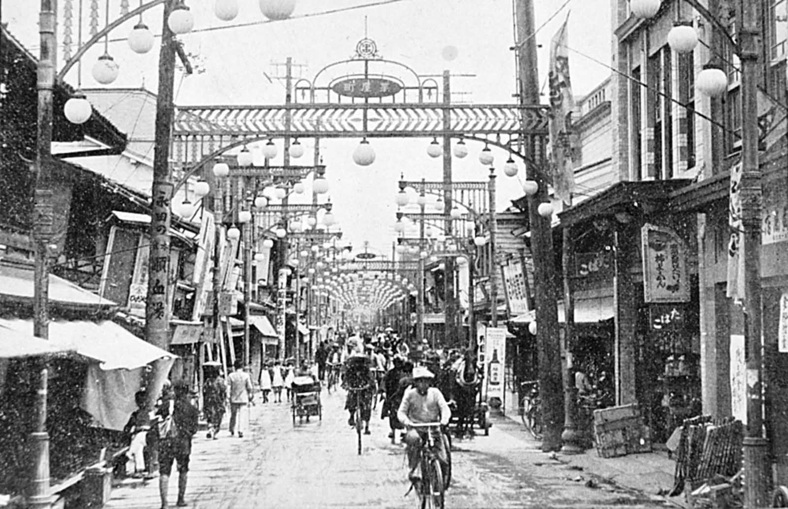 A pre-war photograph of Hiroshima’s vibrant downtown shopping district near the center of town, facing east. Only rubble and a few utility poles remained after the nuclear explosion and resultant fires.