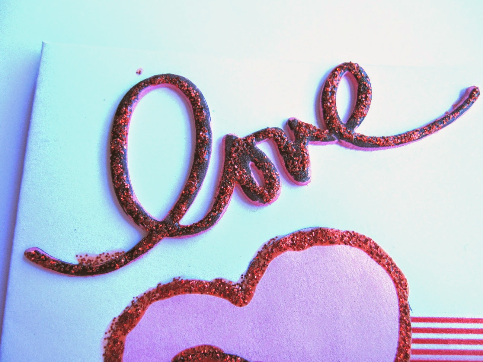 detalle tarjeta scrapbooking de San Valentin con la palabra LOVE negra y resaltada con glitter glue rojo