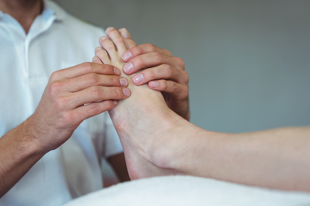 A doctor examines a patient's foot and ankle