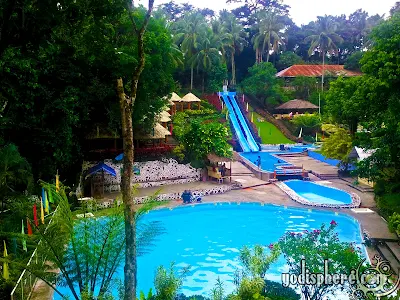 Full photo of the mountain resort with main swimming pool, slide and garden  