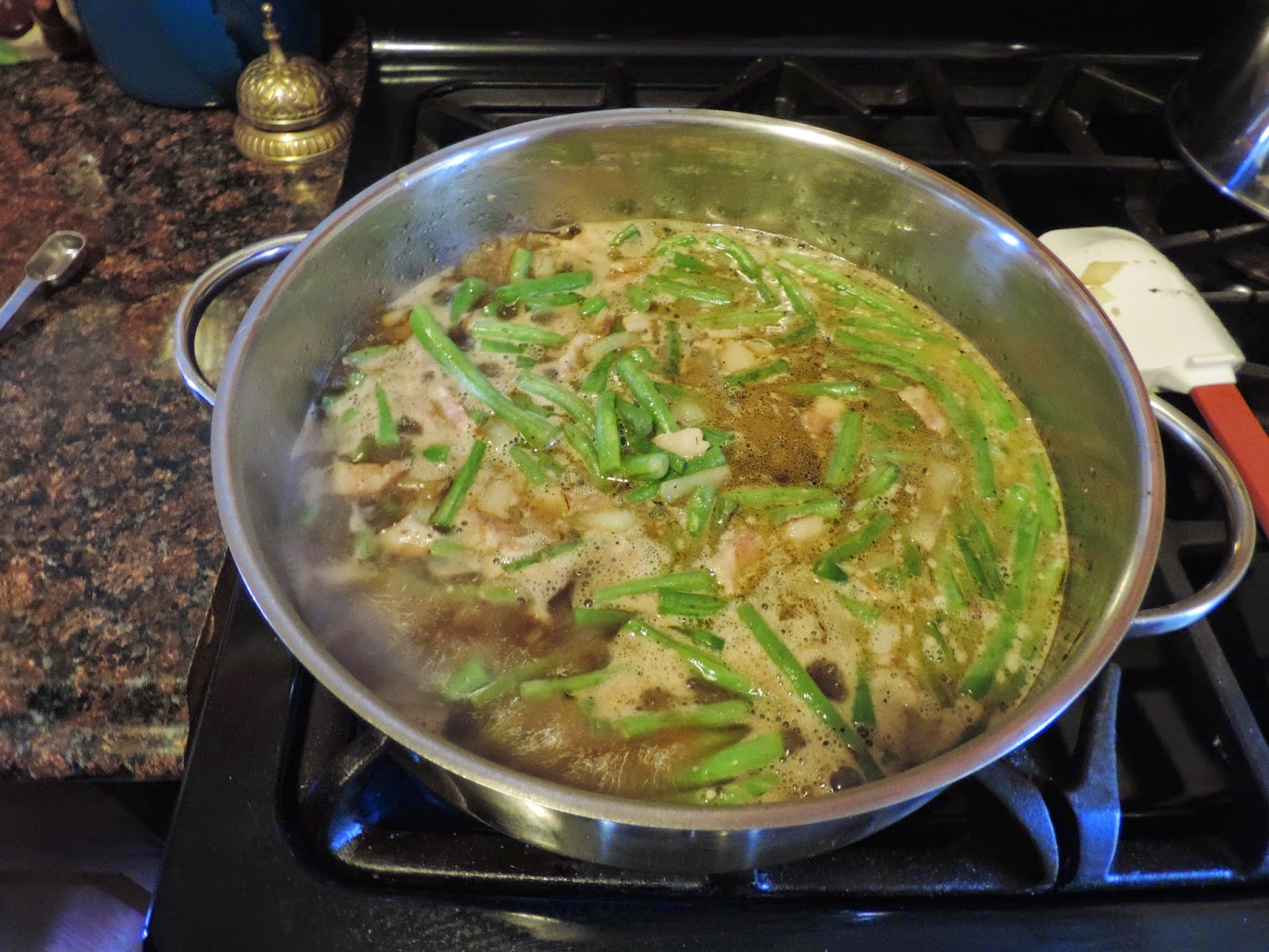 The country-styled green beans simmering in a pot. 