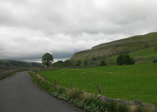 Clouds looming over the countryside, sheep in field, Yorkshire Dales, England