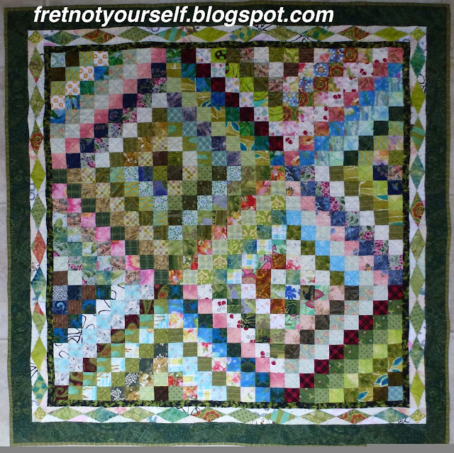 Scrappy Trip Around the World quilt with Diamond border Scrappy Trip baby quilt with diamond border. Green and pink