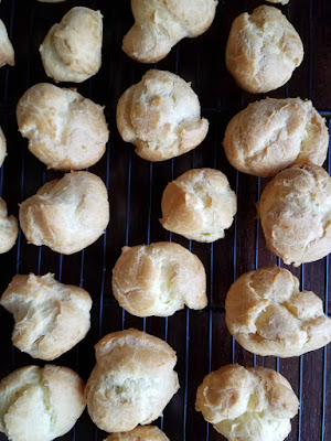 freshly baked cream puffs cooling on wire rack