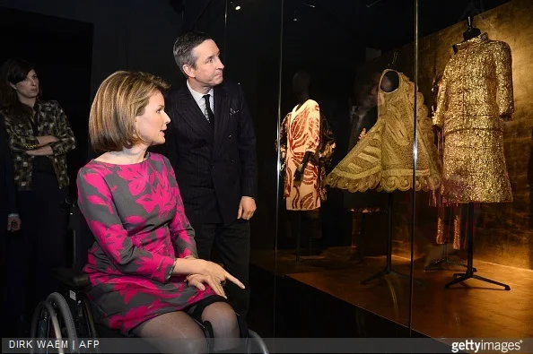 Queen Mathilde of Belgium and fashion designer Dries Van Noten look at creations displayed in the exhibition 'Dries Van Noten. Inspirations