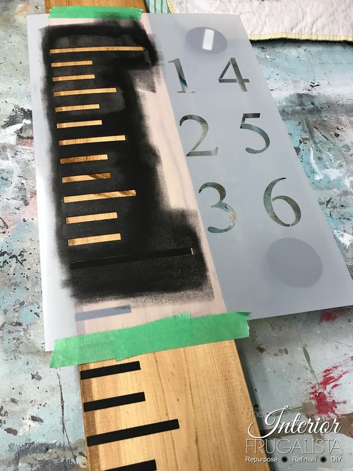 Laying the growth chart stencil flat to prevent paint bleed.