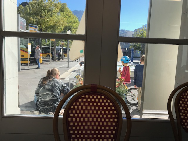 スイス　バートラガツの駅構内のお店でピザを食べながら、外の町の人々を眺める