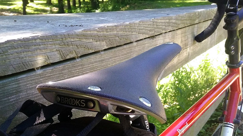 Brooks Cambium Saddle angle view in front of fence