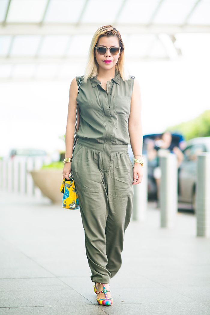 Crystal Phuong in airport attire army green jumpsuit and multi colors rockstud heels