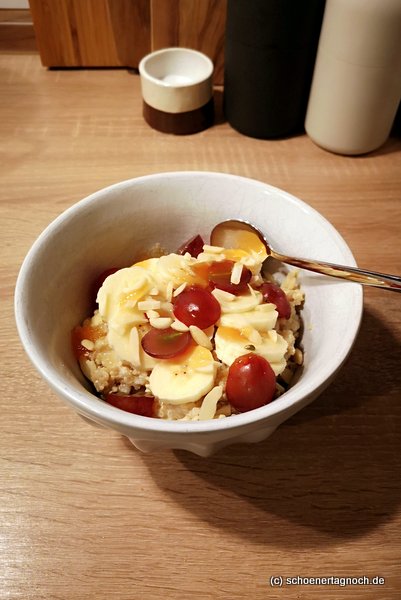 Quinoa-Porridge mit Mandelmilch, Bananen, Weintrauben, Mandelstiften und Honig Quinoa-Porridge mit Mandelmilch, Bananen, Weintrauben, Mandelstiften und Honig