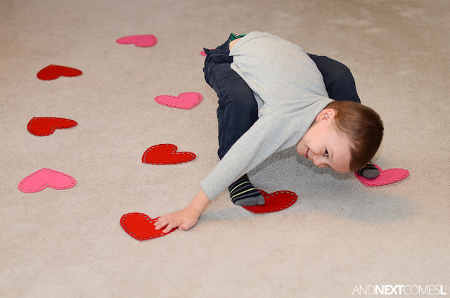 Preschool child playing twister like game with felt hearts as part of a Valentine's Day gross motor activity Preschool child playing twister like game with felt hearts as part of a Valentine's Day gross motor activity