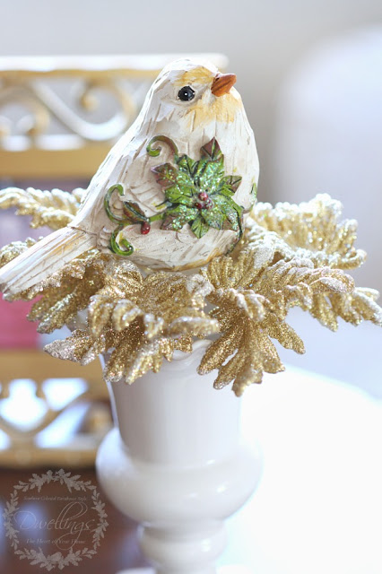 Christmas birds on glittery gold ornament just on top of a vase.