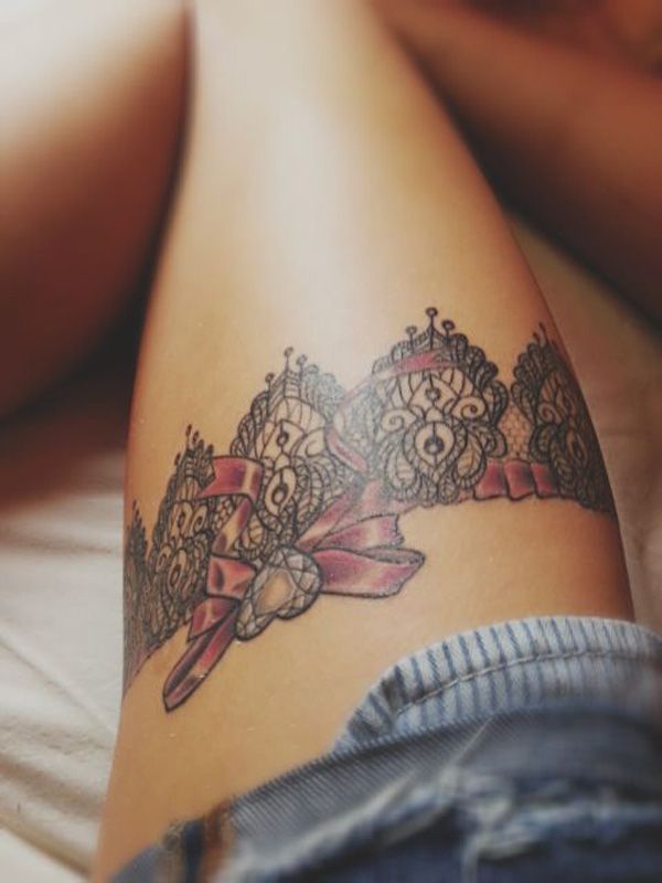 tatuaje de liguero en la pierna con un diamante en el centro del lazo