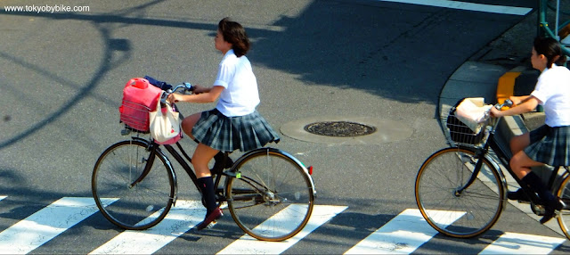 Schoool girls cycling to school in Tokyo Japan