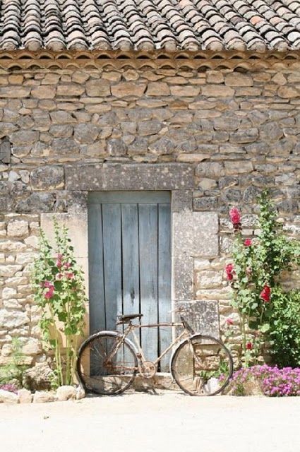 Stone French farmhouse exterior with clay roof and vintage bicycle on Hello Lovely Studio #Frenchfarmhouse #stonecottage #Frenchcottage
