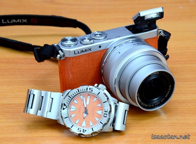 The Lumix GM1 with lens extended, flash popped up, photographed with my matching Seiko Orange Monster watch