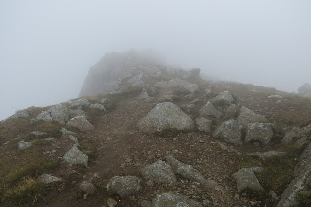 A narrow path following a cliff edge in mist.