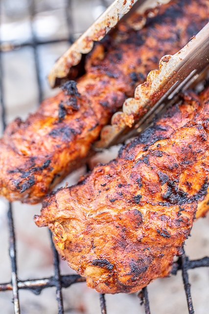 Orange Chipotle Grilled Pork Tenderloin - only 4 ingredients including the pork! So simple and packed FULL of amazing flavor! Pork tenderloin marinated in orange juice, BBQ sauce and chipotle chili powder. Drizzle cooked pork with more BBQ sauce. Great for lunch, dinner and cookouts. SO easy and delicious! #pork #grill #grilling #grilledpork #porktenderloin pork tenderloin cooking on the grill