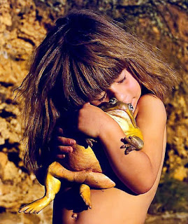 young girl hugging a very large bullfrog